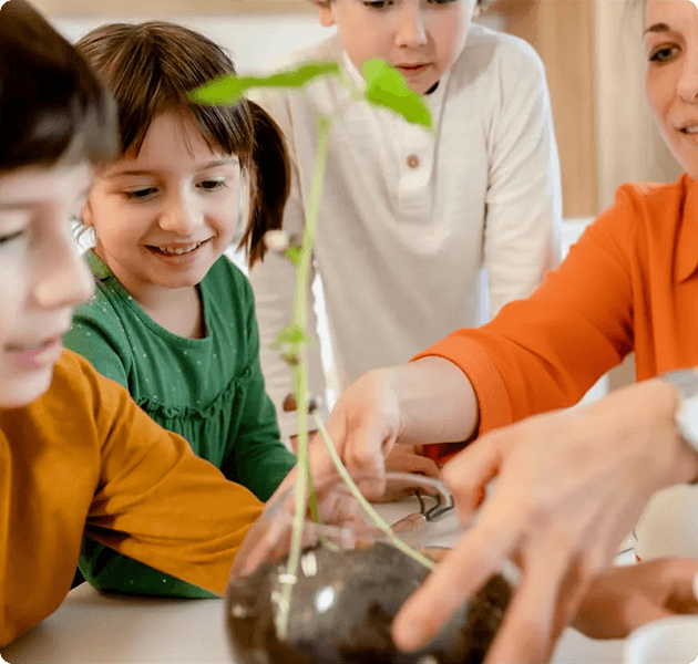 Dzieci uczące się o przyrodzie, trzymające sadzonkę rośliny
